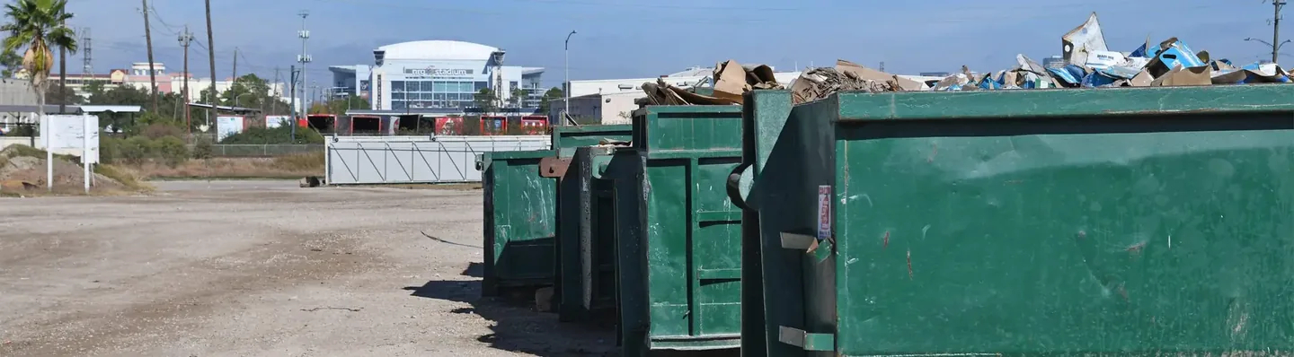 Loaded commercial roll-off containers in a Houston disposal yard
